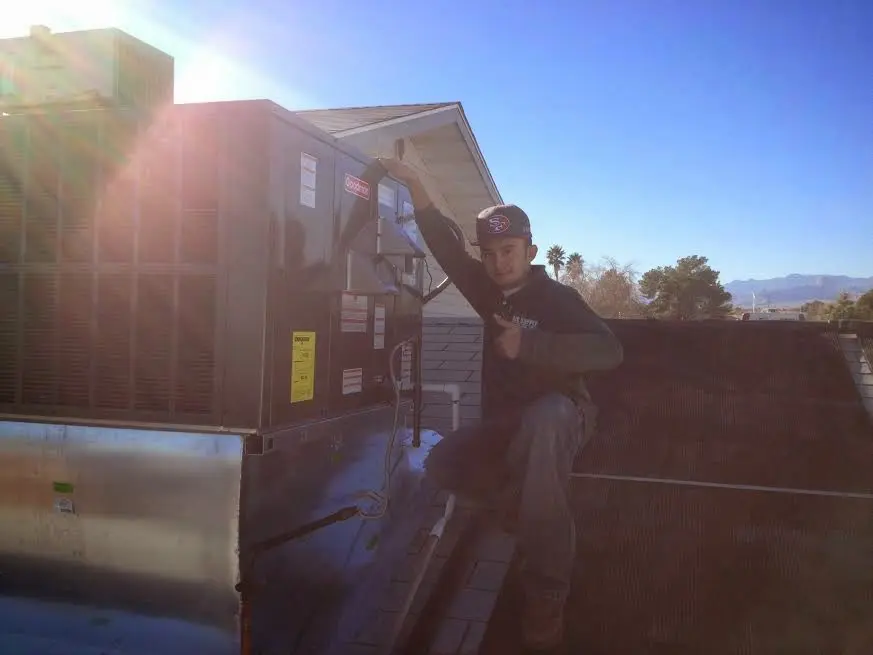 HVAC technician performing Air Duct Cleaning on a rooftop unit in Athol